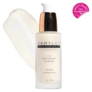 Szklana butelka serum Drmtlgy L.A. Refining Serum z białym dozownikiem i złotą pompką. Na etykiecie widnieje napis „Renew – exfoliate/smooth”, informujący o działaniu złuszczającym i wygładzającym produktu. W tle widać przeźroczystą, żelową konsystencję serum. W prawym górnym rogu znajduje się różowa odznaka „Beauty Awards 2023 – NewBeauty”.