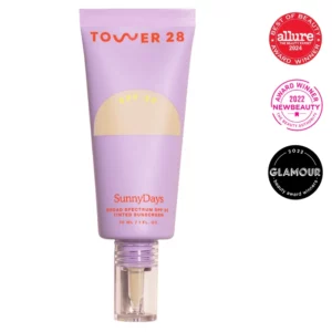 Zdjęcie przedstawia filtr przeciwsłoneczny Tower 28 Sunny Days w fioletowej tubce z żółtą etykietą, oznaczony jako Allure Best of Beauty 2024 oraz Glamour i NewBeauty 2022 Award Winner.