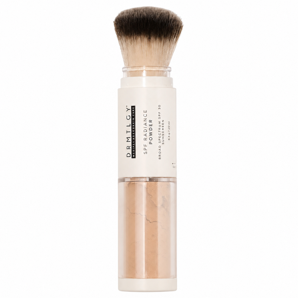 Drmtlgy SPF 30 Radiance Powder Medium Tan Puder mineralny DRMTLGY SPF Radiance Powder SPF 30 w odcieniu Medium Tan z aplikatorem w formie miękkiego pędzla, pokazany na białym tle.