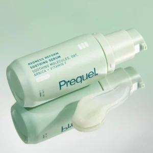 Prequel Redness Reform Soothing Serum - miętowe opakowanie kojącego serum do twarzy pokazane z kremową teksturą produktu i lustrzanym odbiciem na jasnym tle. Serum przeznaczone do pielęgnacji skóry wrażliwej i skłonnej do zaczerwienień.