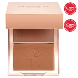 Zdjęcie przedstawia produkt marki Patrick Ta, który jest dwukolorowym bronzerem do twarzy zamkniętym w eleganckim, metalicznym opakowaniu. Produkt został wyróżniony nagrodą Allure Best of Beauty w 2023 i 2024 roku. Wewnątrz opakowania znajduje się bronzer w dwóch odcieniach: prasowany matowy puder oraz kremowy bronzer, umożliwiający uzyskanie złożonego efektu makijażu z konturowaniem i ociepleniem twarzy.
