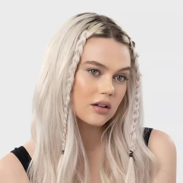 Kitsch no snag elastic Modelka z jasnymi, rozpuszczonymi włosami, ozdobionymi dwoma cienkimi warkoczami z przodu. Jej włosy utrzymują naturalny, swobodny styl, a fryzura podkreśla minimalistyczny, codzienny wygląd.