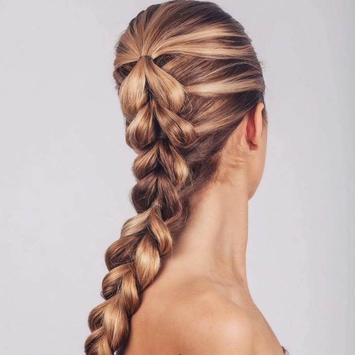 Kitsch no snag elastic Modelka z eleganckim warkoczem francuskim, który zaczyna się na czubku głowy i przechodzi w gruby, schludny warkocz biegnący w dół. Włosy są starannie ułożone, z subtelnymi pasemkami, podkreślającymi teksturę fryzury. Fryzura idealna na formalne wydarzenia lub codzienny elegancki styl.
