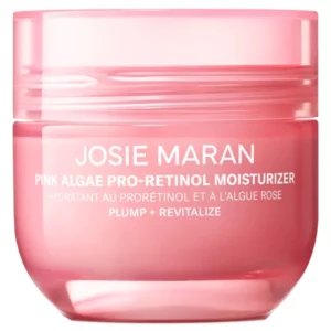 Słoiczek Josie Maran Pink Algae Pro-Retinol Moisturizer w różowym opakowaniu z białym napisem. Na opakowaniu widnieje slogan 'Plump + Revitalize'.