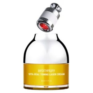 Na zdjęciu widoczny jest produkt Meditherapy Vita Real Toning Laser Cream, który składa się z eleganckiego słoiczka w srebrno-żółtym kolorze oraz kompaktowego urządzenia LED. Słoiczek zawiera krem do pielęgnacji skóry, a urządzenie z czerwonym światłem LED (widoczne nad pojemnikiem) przeznaczone jest do masażu i wspomagania wchłaniania składników aktywnych. Design produktu jest nowoczesny i luksusowy, podkreślający zaawansowaną technologię i profesjonalny charakter pielęgnacji. Krem dostępny jest w opakowaniu o pojemności 50 ml.