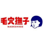Logo marki Keana Nadeshiko – stylizowana ilustracja twarzy kobiety z grzywką i drobnymi kropkami na policzkach, symbolizującymi rozszerzone pory. Twarz wykonana jest w granatowym kolorze, co kontrastuje z czerwonymi japońskimi znakami obok. Poniżej znajduje się angielska nazwa „NADESHIKO” zapisana dużymi, czerwonymi literami. Logo ma minimalistyczny i nowoczesny charakter, nawiązujący do japońskiej pielęgnacji skóry.