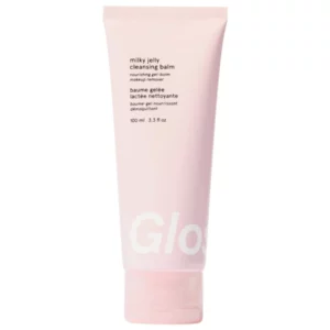 Różowa tubka produktu do pielęgnacji skóry o nazwie „Milky Jelly Cleansing Balm” marki Glossier. Opakowanie ma minimalistyczny design i zawiera napisy w języku angielskim i francuskim.