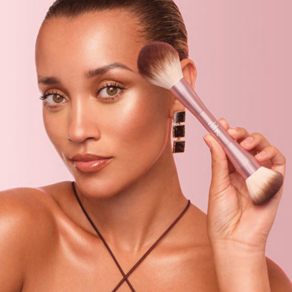 Dibs-Duo-Brush-Face (2) Kobieta aplikująca makijaż pędzlem DIBS duo brush na policzku efekt glow i konturowanie twarzy.