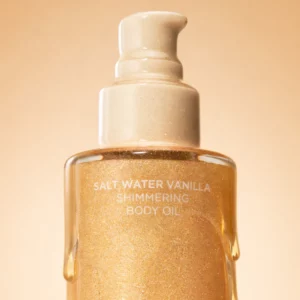 Saltair Salt Water Vanilla Shimmering Body Oil – złoty olejek do ciała z połyskiem, wyśrodkowana butelka z efektem spływającej konsystencji i glow.