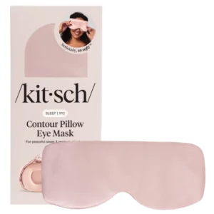Różowa maska na oczy Kitsch z opakowaniem w tle, przedstawiającym kobietę w różowej masce na oczy.