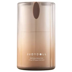 Zbliżenie na pojedyncze opakowanie JUDYDOLL Mattifying Makeup Base, w eleganckim, gradientowym pojemniku w odcieniach beżu i brązu, przedstawione na białym tle.
