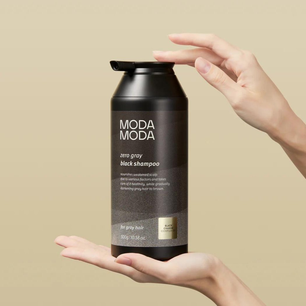 Modamoda Black Shampoo 10 Zero Grey (2) Butelka szamponu MODA MODA Zero Gray Black Shampoo trzymana w dłoniach na jasnym tle, prezentująca minimalistyczne, eleganckie opakowanie.