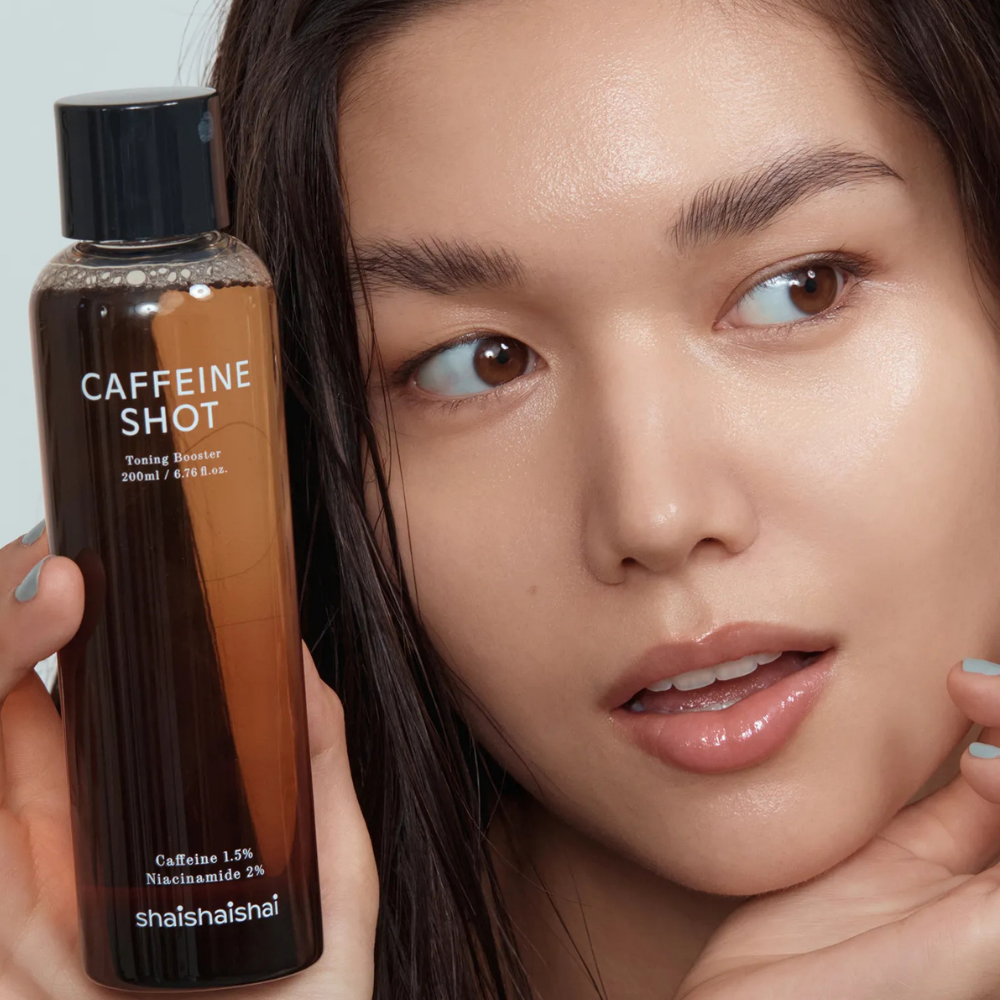 Shaishaishai - Caffeine Shot Toner Twarz Azjatki z półprofilu, na pierwszym planie opakowanie produktu.