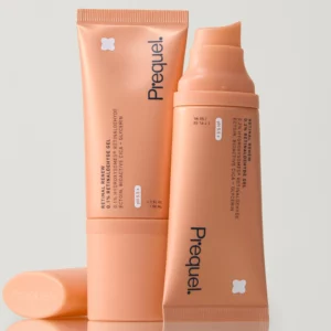 Prequel Retinal Renew 0.2% Retinaldehyde Gel - brzoskwiniowe opakowania żelu z 0,2% retinaldehydu pokazane w minimalistycznej, studyjnej aranżacji. Na zdjęciu widoczna jest tubka oraz otwarte opakowanie z pompką, prezentujące kosmetyk do wieczornej pielęgnacji skóry z oznakami starzenia, nierówną teksturą i drobnymi liniami.