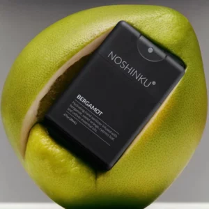 Noshinku Bergamot umieszczony w zielonym grejpfrucie, nawilżający spray do dezynfekcji rąk z nutą bergamotki i cytrusów.