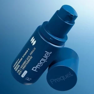 Prequel Lucent-C Brightening Vitamin C Serum - granatowe opakowanie rozświetlającego serum z witaminą C 15%, pokazane z pompką i nakrętką na niebieskim tle. Serum do pielęgnacji skóry z przebarwieniami, nierównym kolorytem i oznakami utraty blasku.