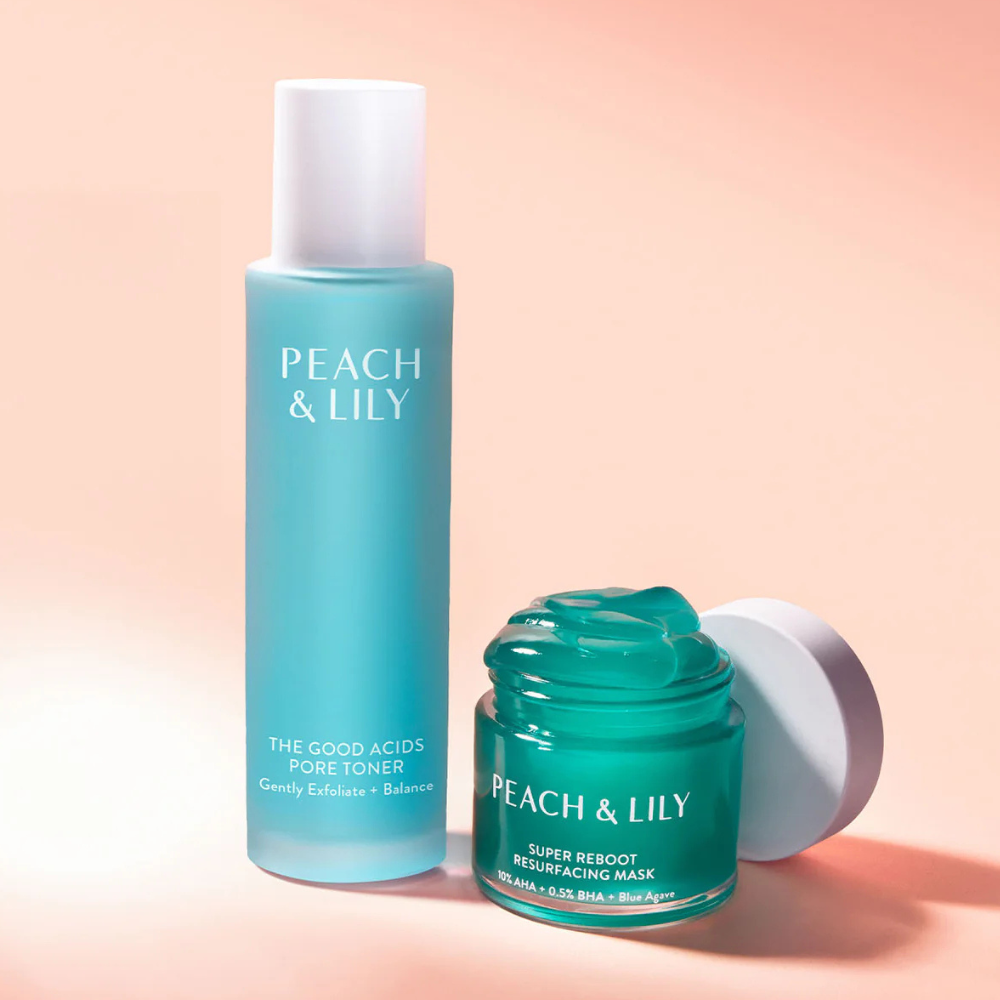 Peach-Lily-The-Good-Acids-Pore-Toner (2) Tonik Peach & Lily The Good Acids Pore Toner w błękitnej butelce obok maski Super Reboot Resurfacing Mask na pastelowym, brzoskwiniowym tle – zestaw produktów pielęgnacyjnych o świeżym i nowoczesnym wyglądzie.