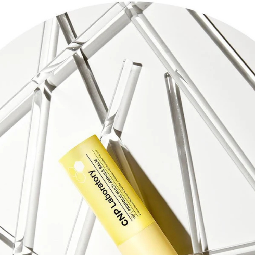 CNP Laboratory Propolis Multi Ampule Balm CNP Laboratory Propolis Multi Ampule Balm otoczony laboratoryjnymi probówkami ze złocistą formułą inspirowaną propolisem.