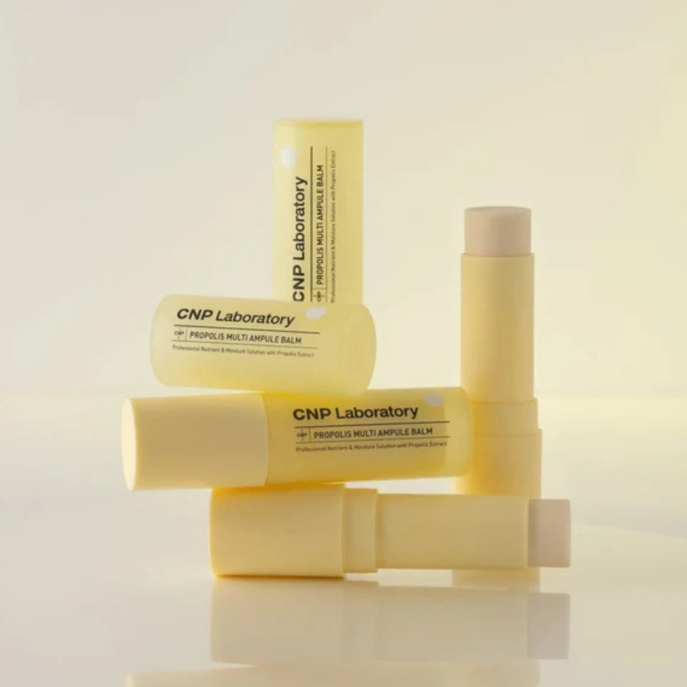 CNP Laboratory Propolis Multi Ampule Balm Otwarty balsam w sztyfcie CNP Laboratory Propolis Multi Ampule Balm na świetlistym, miodowo-złotym tle z subtelnymi motywami propolisu.