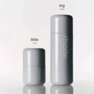 Dwie szare butelki Rhode Glazing Milk w rozmiarach Little 1.7 oz i Big 4.2 oz, ustawione obok siebie na jasnym tle.
