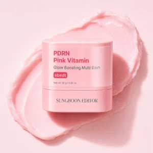 Packshot różowego sztyftu Sungboon Editor PDRN Pink Vitamin Glow Boosting Multi Balm na pastelowym tle z kremową teksturą produktu i efektem glossy glow.