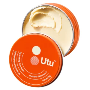 Pomarańczowy balsam przeciwsłoneczny Utu Hydrating Sun Balm SPF50 w metalowym opakowaniu z widoczną kremową konsystencją na jasnym tle.