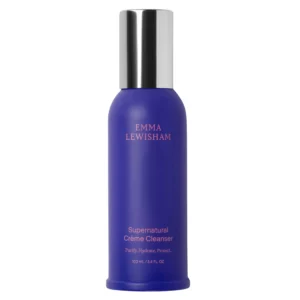 Packshot Emma Lewisham Supernatural Crème Cleanser 100 ml na jasnym tle. Fioletowa butelka z metaliczną srebrną nakrętką zawiera kremowy żel do mycia twarzy wspierający nawilżenie, komfort skóry i ochronę bariery hydrolipidowej.
