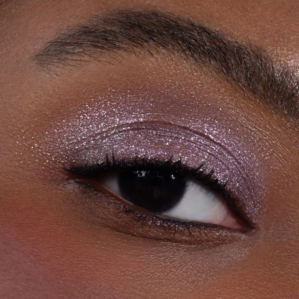 Half Magic Eyeshadow (2) Na zdjęciu znajduje się makijaż oka wykonany połyskującym cieniem Half Magic Beauty w chłodnym, liliowo-różowym odcieniu z wielowymiarowym blaskiem.