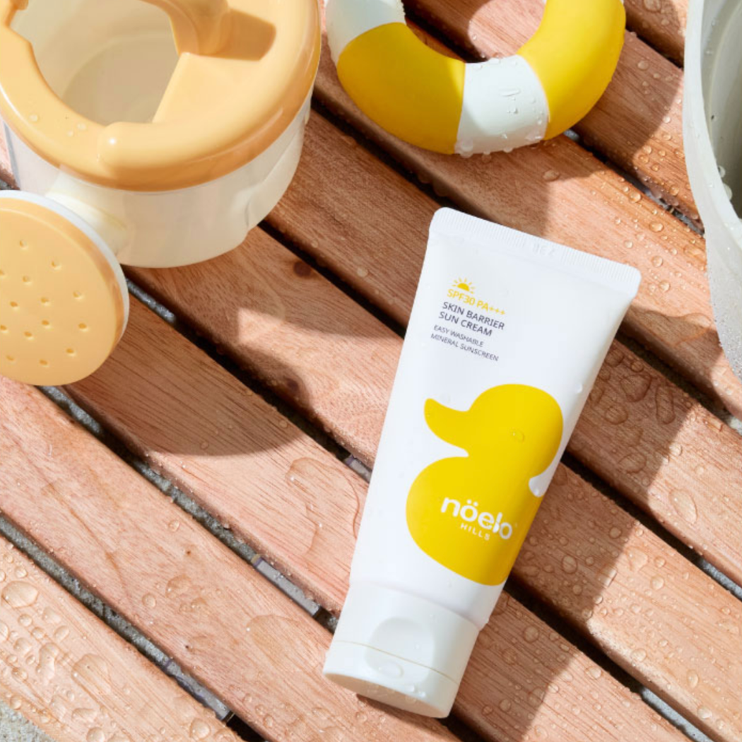 Noelo Hills Skin Barrier Sun Cream SPF 30 Noelo Hills Skin Barrier Sun Cream SPF30 PA+++ w letniej aranżacji przy basenie. Mineralny krem ochronny dla dzieci i niemowląt.