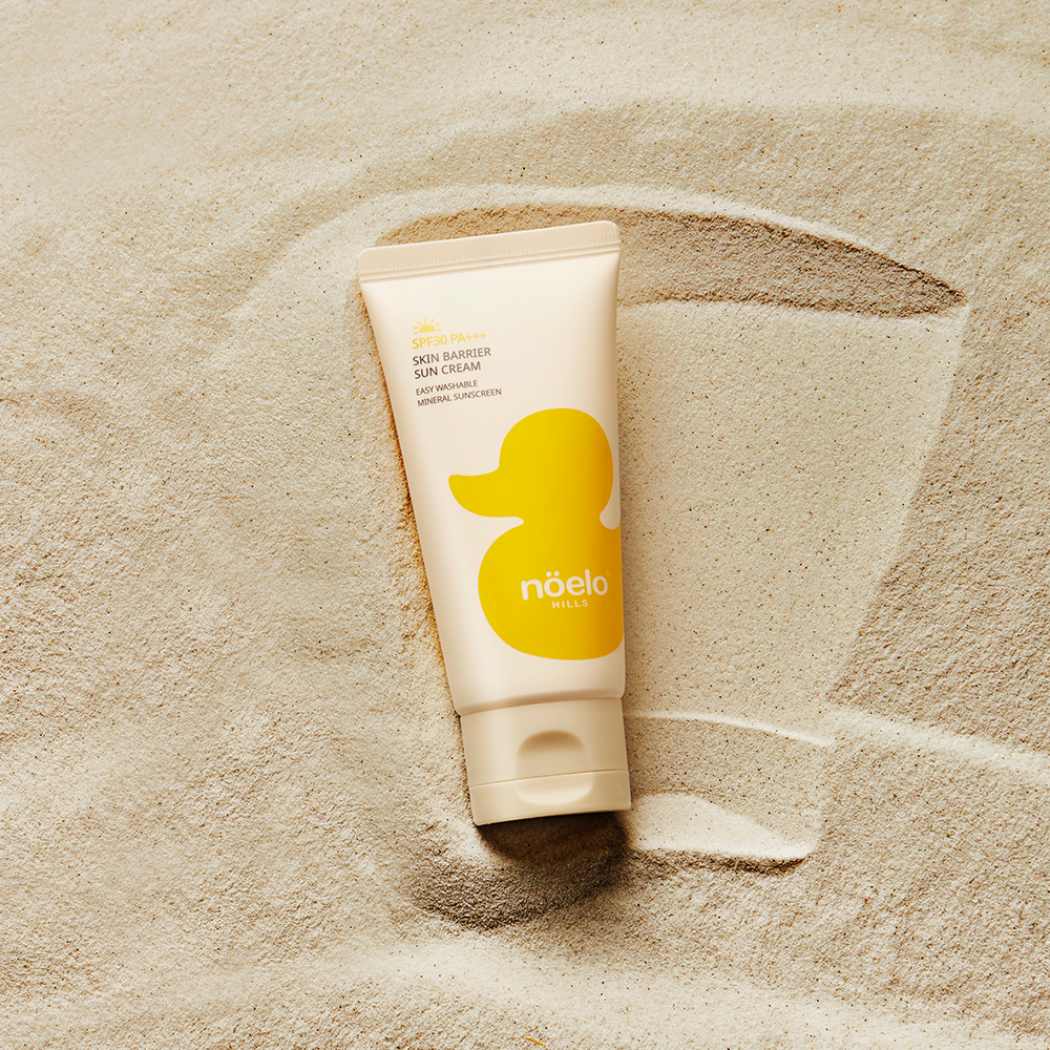 Noelo Hills Skin Barrier Sun Cream SPF 30 Noelo Hills Skin Barrier Sun Cream SPF30 PA+++ prezentowany na jasnym piasku. Delikatny filtr mineralny wspierający ochronę wrażliwej skóry.