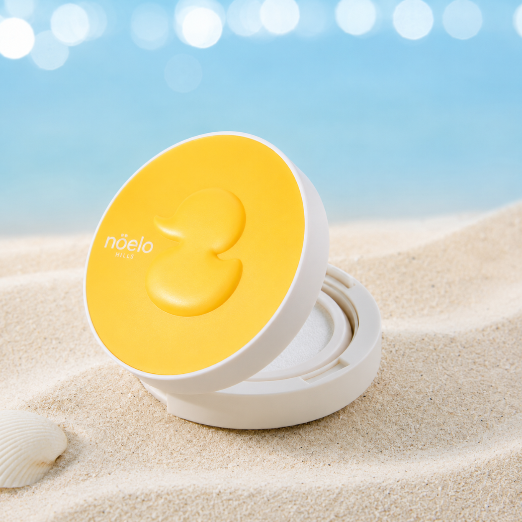 Noelo Hills Skin Barrier Sun Cushion SPF 50 (3) Noelo Hills Skin Barrier Sun Cushion SPF50+ PA++++ otwarty na piaszczystej plaży. Mineralny cushion przeciwsłoneczny do szybkiej reaplikacji ochrony UV.