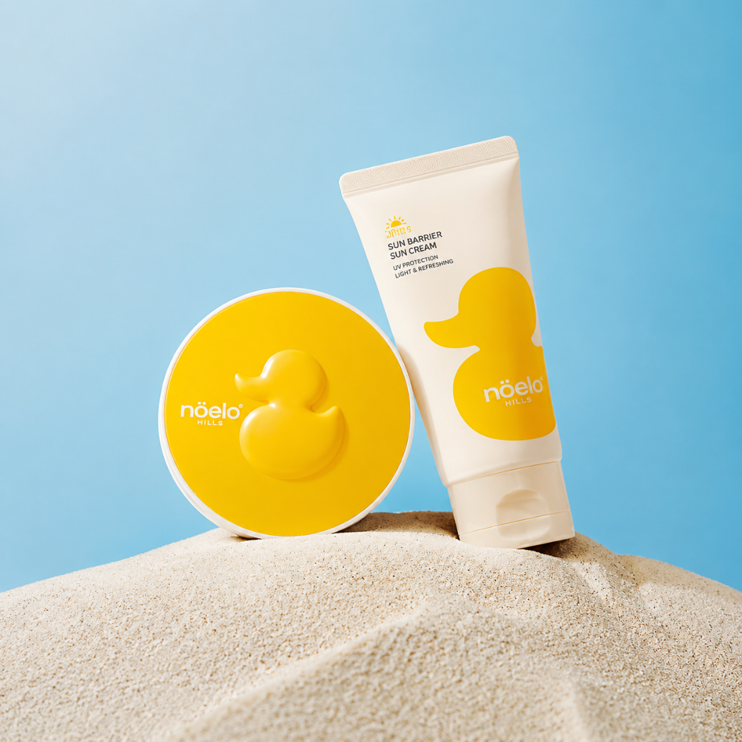 Noelo Hills Skin Barrier Sun Cushion SPF 50 Noelo Hills Skin Barrier Sun Cushion SPF50+ PA++++ oraz Skin Barrier Sun Cream SPF30 PA+++ na piasku. Mineralna ochrona przeciwsłoneczna dla dzieci i skóry wrażliwej.
