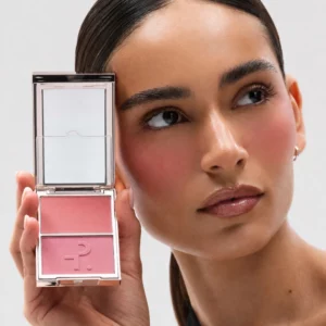 Modelka prezentująca Patrick Ta Double-Take Blush przy twarzy, z widocznym różowym rumieńcem na policzkach.