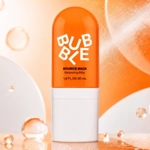 Bubble Bounce Back Balancing Toner Mist 55 ml przedstawiona na dynamicznym pomarańczowo-białym tle z dekoracyjnymi kroplami wody.