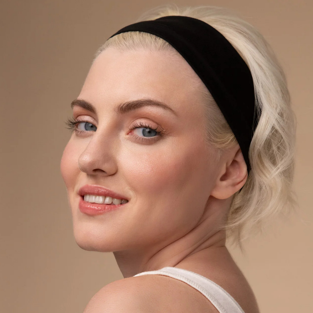 Kitsch Active Headbands Kobieta o krótkich blond włosach nosząca szeroką czarną opaskę do włosów Kitsch.