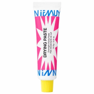 Na zdjęciu znajduje się INNBEAUTY Project Drying Paste – wysuszająca pasta na niedoskonałości w biało-różowej tubce z żółtą zakrętką, ustawiona pionowo na białym tle.
