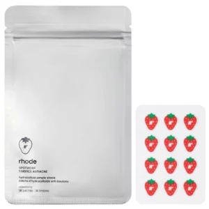 Na zdjęciu znajduje się srebrne opakowanie Rhode Spotwear Hydrocolloid Patches Strawberry oraz arkusz czerwonych plasterków w kształcie truskawek.