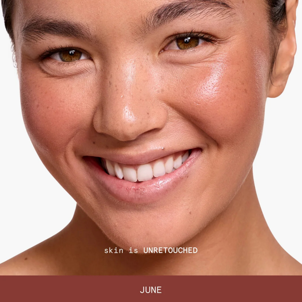 june ciele blush Na zdjęciu znajduje się uśmiechnięta modelka prezentująca ciepły, brązowo-różowy odcień June na policzkach i naturalną teksturę skóry.