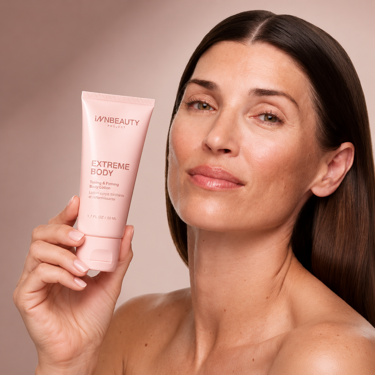 2 INNBEAUTY Project Extreme Body - kobieta trzymająca różową tubkę tonizującego i ujędrniającego balsamu do ciała 50 ml.