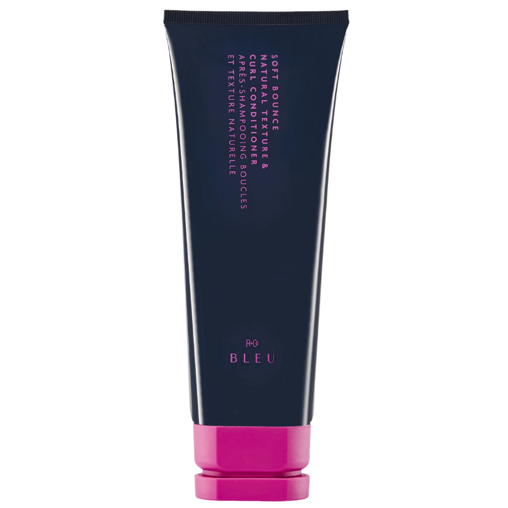 R+Co BLEU Soft Bounce Natural Texture & Curl Conditioner R+Co BLEU Soft Bounce Natural Texture & Curl Conditioner w granatowej tubce z intensywnie różowym zamknięciem na białym tle.