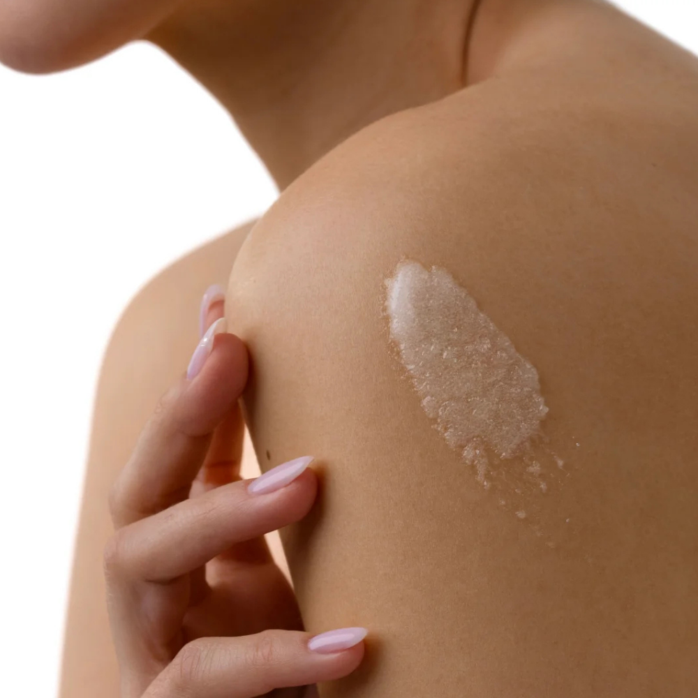 Remedy Science KP Exfoliating Body Scrub Ziarnista konsystencja peelingu Remedy Science KP Exfoliating Body Scrub nałożona na skórę ramienia.