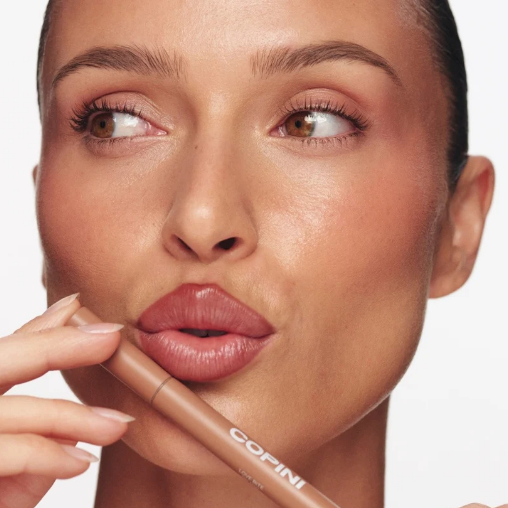 Copini Love Bite Soft Focus Lip Stain (7) Copini Love Bite Soft Focus Lip Stain - efekt Chai - modelka prezentująca naturalny, ciepły odcień Chai na ustach i produkt Copini.
