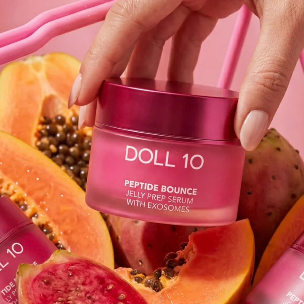 Doll 10 Peptide Bounce Jelly Prep Serum With Exosomes (3) Doll 10 Peptide Bounce Jelly Prep Serum With Exosomes - różowe serum-żel do twarzy prezentowane w otoczeniu papai i opuncji figowej.