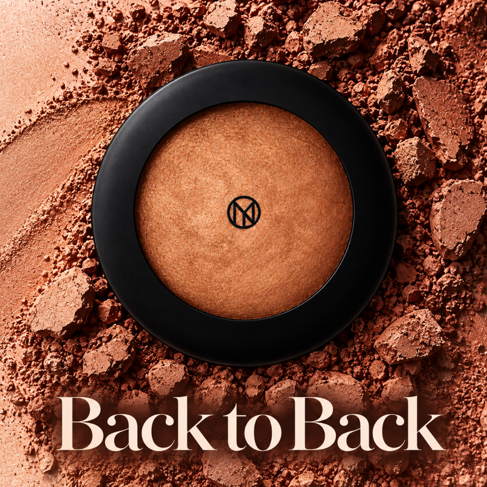 IL MAKIAGE Mineral Baked Bronzer - mineralny wypiek słońca IL MAKIAGE Mineral Baked Bronzer w odcieniu Back to Back - wypiekany bronzer w ciepłym brązowo-miedzianym odcieniu, w czarnym opakowaniu, otoczony rozsypanym i rozkruszonym pigmentem.