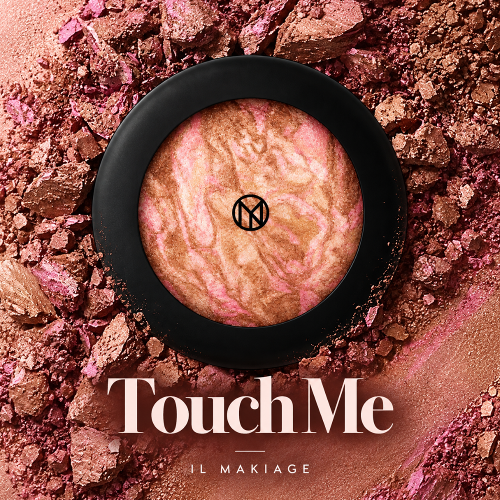 IL MAKIAGE Mineral Baked Bronzer - mineralny wypiek słońca IL MAKIAGE Mineral Baked Bronzer w odcieniu Touch Me - marmurkowy bronzer w różowo-brązowo-złotych tonach, w czarnym opakowaniu, na tle rozkruszonego i rozsypanego pigmentu, z podpisem nazwy odcienia.