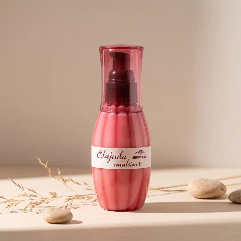Milbon Elujuda Hair Treatment Emulsion (2) Milbon Elujuda Emulsion+ - odżywcza emulsja bez spłukiwania do włosów w różowym opakowaniu z pompką, przedstawiona w minimalistycznej aranżacji.