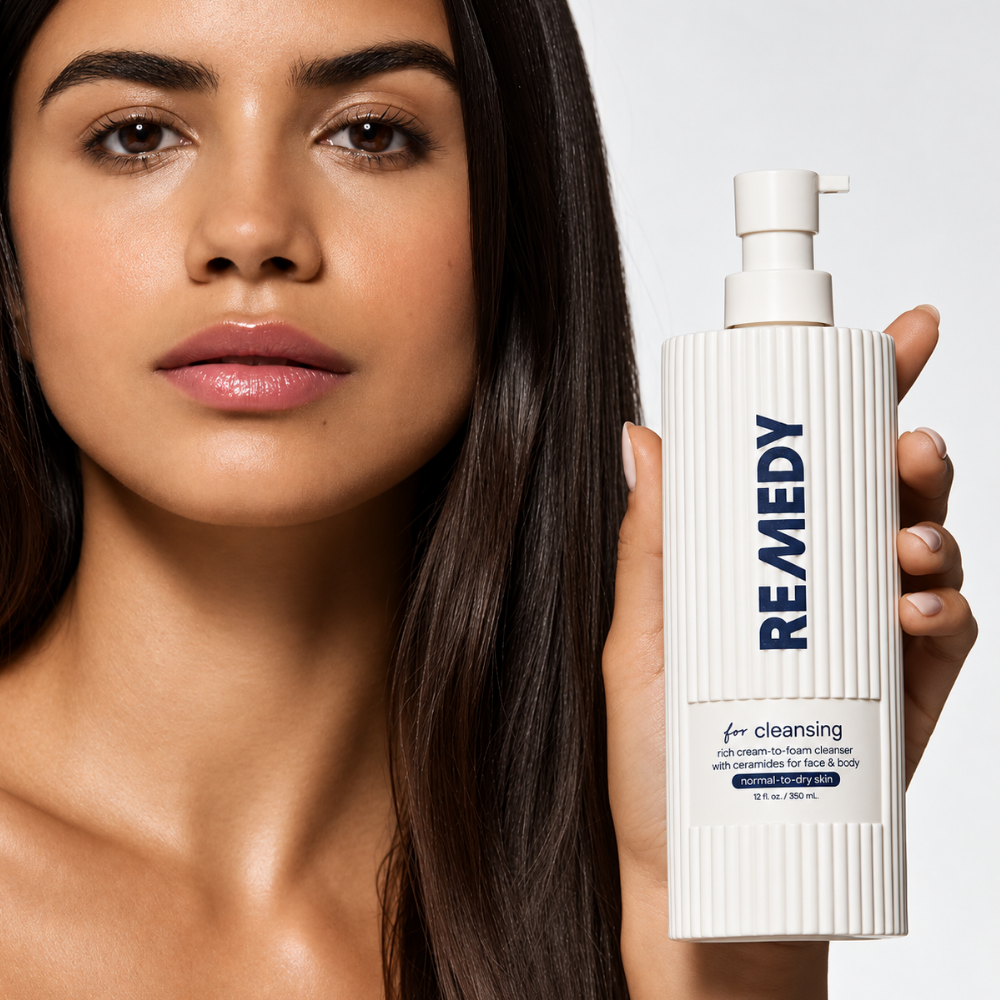 Remedy Cream To Foam Cleanser with Ceramides - czysta przyjemność (7) REMEDY Cream-to-Foam Cleanser with Ceramides - kobieta prezentująca kremowy preparat oczyszczający z ceramidami w dużej butelce z pompką, przeznaczony do skóry normalnej i suchej.