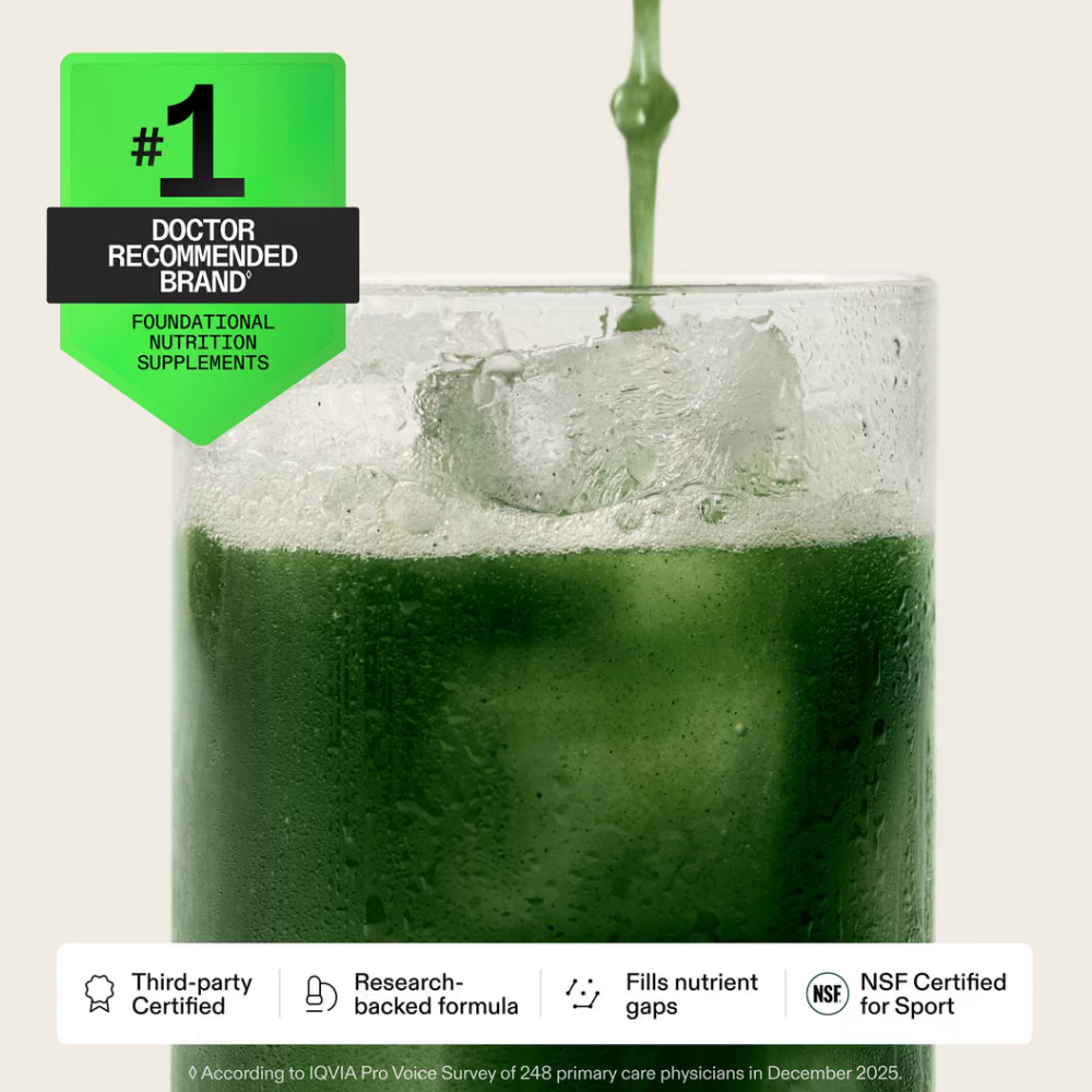 AG1 Daily Foundational Multivitamin Greens Powder (2) Szklanka z zielonym napojem AG1 Daily Foundational Multivitamin Greens Powder, kostkami lodu i delikatną pianką na jasnym tle. Grafika przedstawia suplement diety w formie napoju oraz informacje o certyfikacji i rekomendacjach marki.