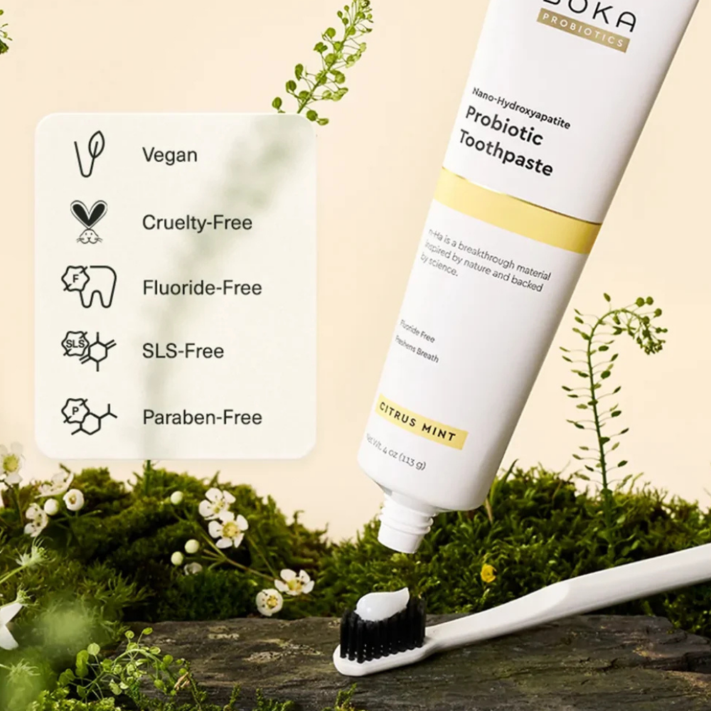 Citrus Mint Probiotic Nano-hydroxyapatite Toothpaste (2) Boka Citrus Mint Probiotic Toothpaste - nowoczesna pasta do zębów z nanohydroksyapatytem i probiotykami, opracowana z myślą o pielęgnacji szkliwa i mikrobiomu jamy ustnej. Biała tubka z żółtymi akcentami prezentowana na naturalnym tle z mchem i kwiatami.
