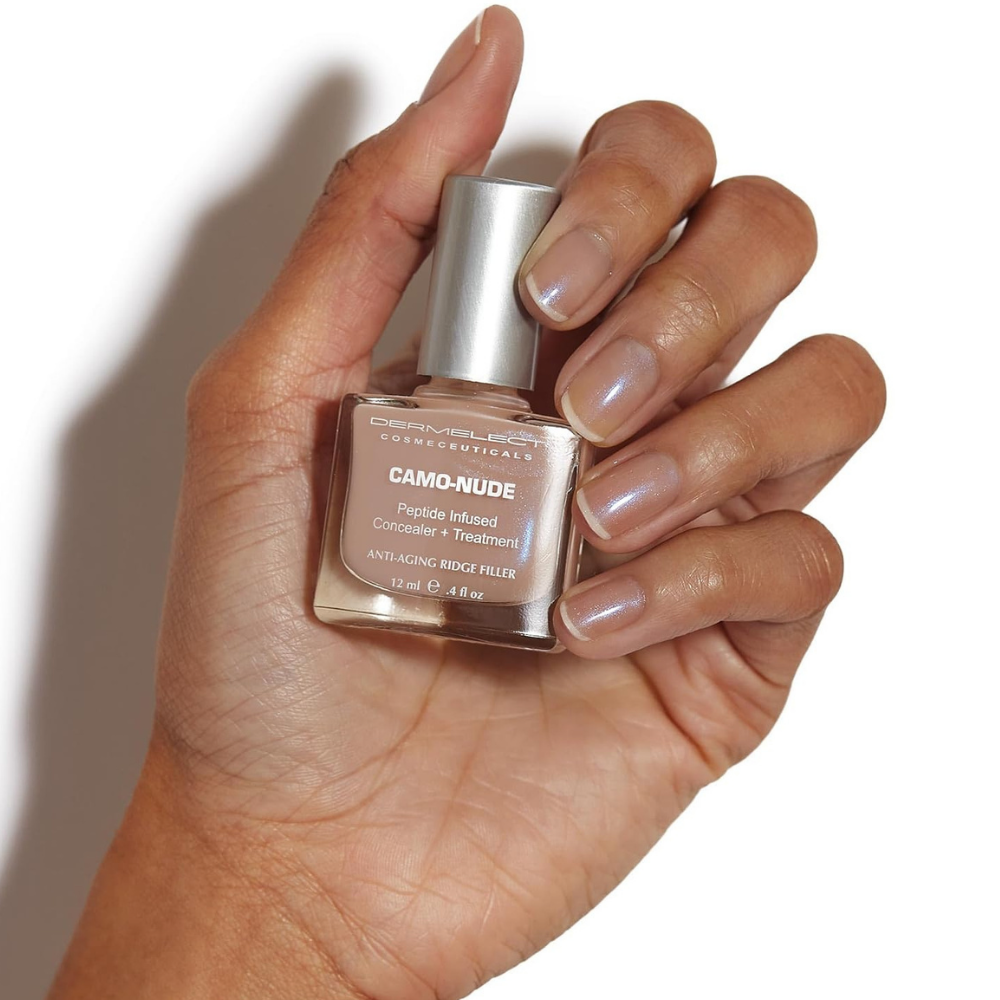 Dermelect Camo-Nude Concealer + Treatment (2) Zbliżenie na paznokcie pokryte Dermelect Camo-Nude Concealer + Treatment. Delikatny różowo-beżowy odcień z subtelnym opalizującym połyskiem optycznie wygładza płytkę i nadaje jej zadbany wygląd.